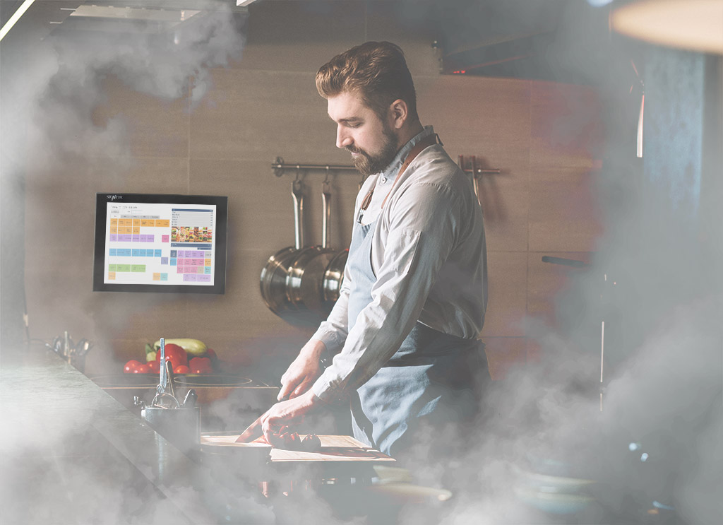 SENOR_A chef cooks in a smoky central kitchen through the Kitchen Display System (KDS),It provides real-time information and data to enhance kitchen efficiency.