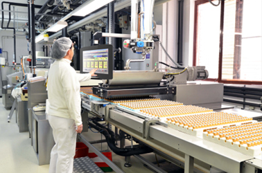 In a food factory, a professional is checking the production progress by operating a Senor stainless steel panel PC.